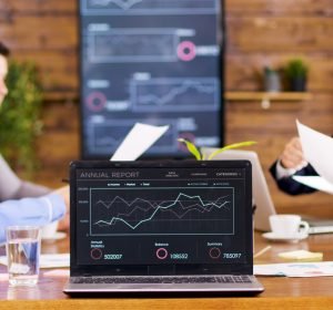 table-laptop-showing-charts-conference-room-business-people-having-important-discussion-scaled.jpg